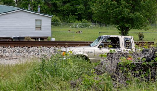 Grass growing around a truck with shattered windows
