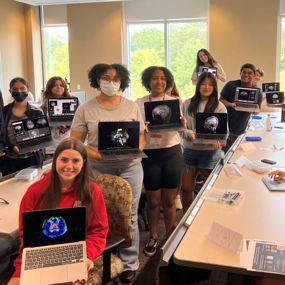 Students hold scans of their brains at Auburn University Brain Camp