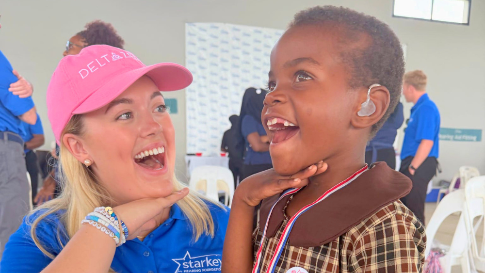 caylyn turner poses with young girl wearing hearing aid
