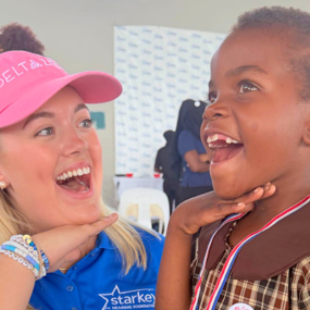 caylyn turner poses with young girl wearing hearing aid