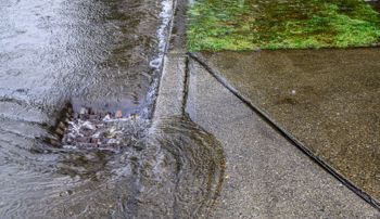 Water pouring down a storm drain during flood