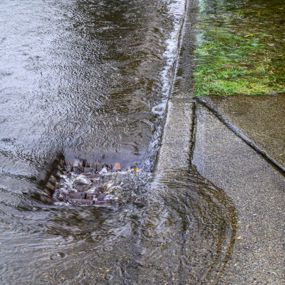 Water pouring down a storm drain during flood