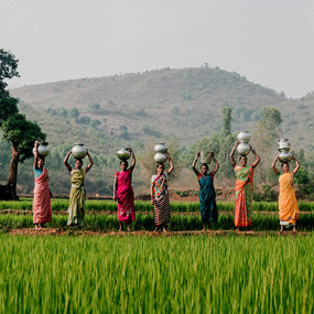 Women in rural Ethiopia balancing water jugs atop their heads