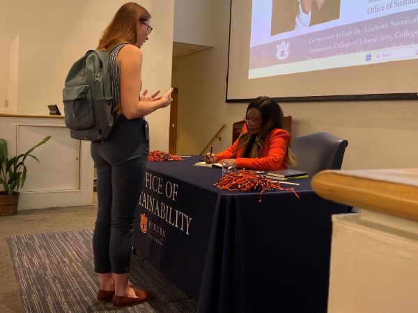 Catherine Flowers signing a book for a student