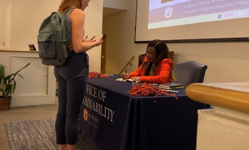 Catherine Flowers signing a book for a student