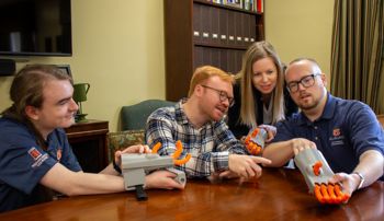 Faculty and students from History and Engineering examining a 3-D model of the Kassel Hand