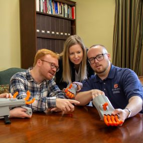 Faculty and students from History and Engineering examining a 3-D model of the Kassel Hand