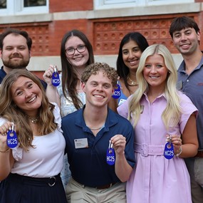 A group of Camp War Eagle student leaders holding up their camp badges