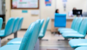 Rows of empty chairs sitting in a hospital waiting room