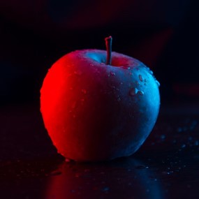 Apple under a gradient of red to blue light