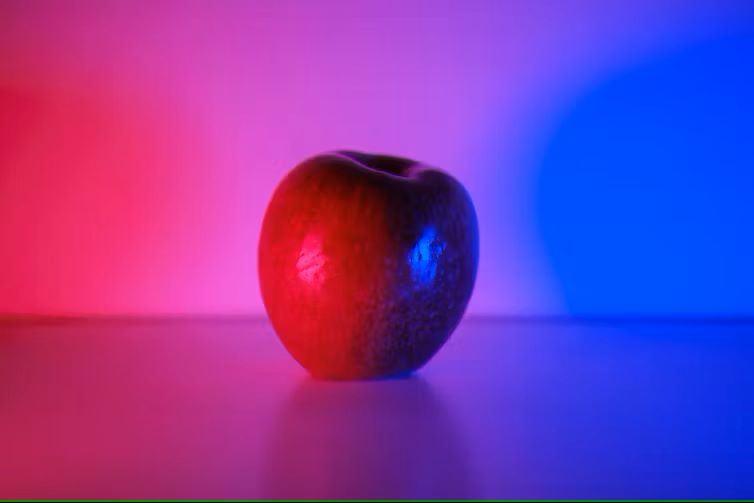 Apple under a gradient of red to blue light