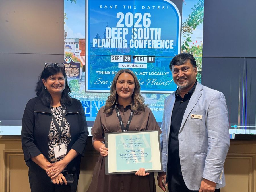 Two professors standing next to Caroline Deck who is holding an award certificate