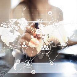 person pointing an ink pen at a screen featuring a world map