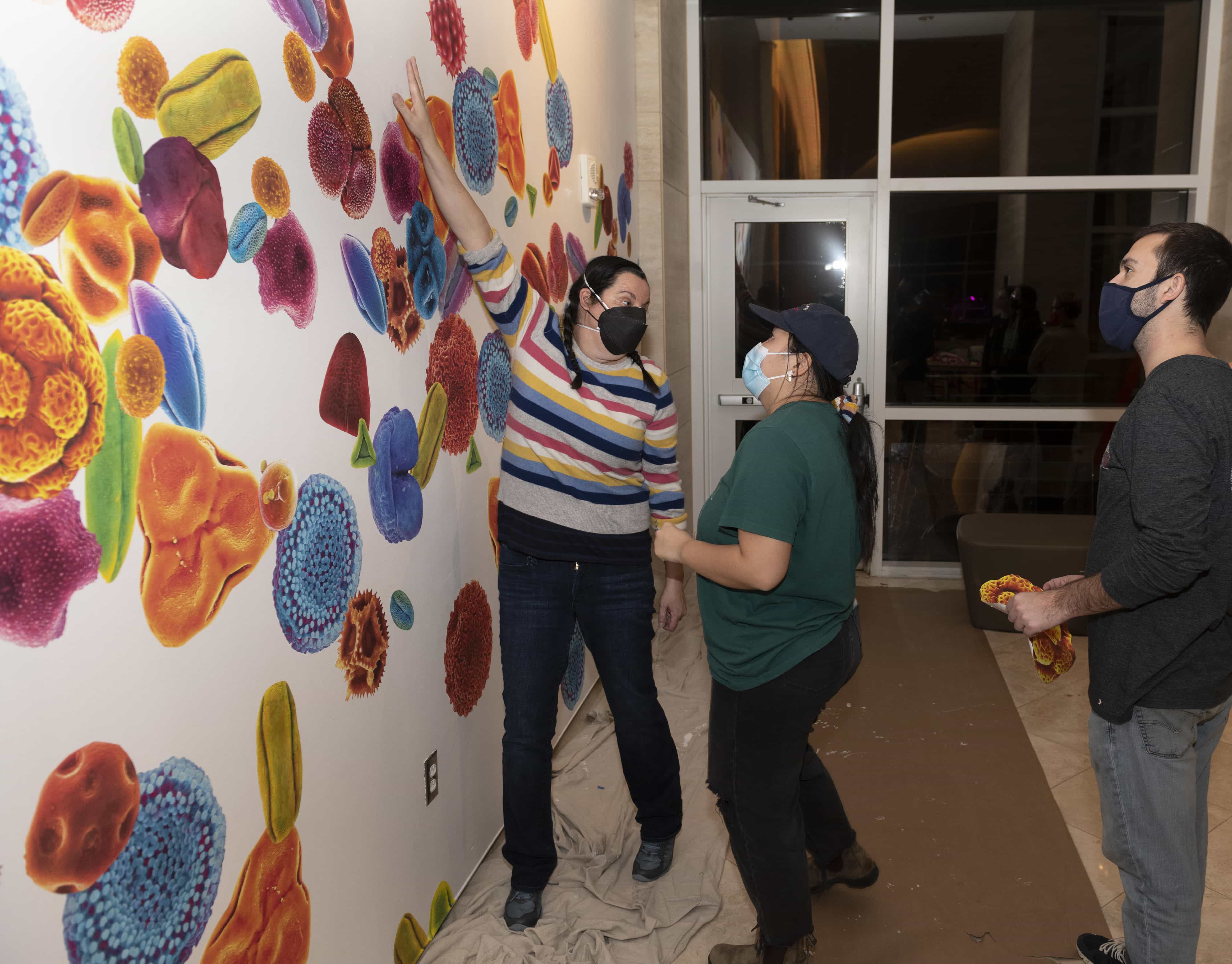 Professor Wendy DesChene working with students to build an exhibit