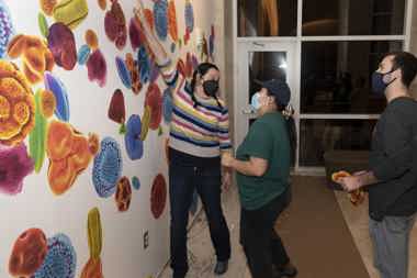 Professor Wendy DesChene working with students to build an exhibit