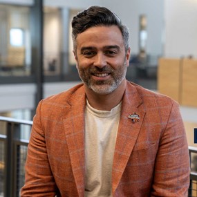 Brian Pultro poses for a picture with an atrium behind him.