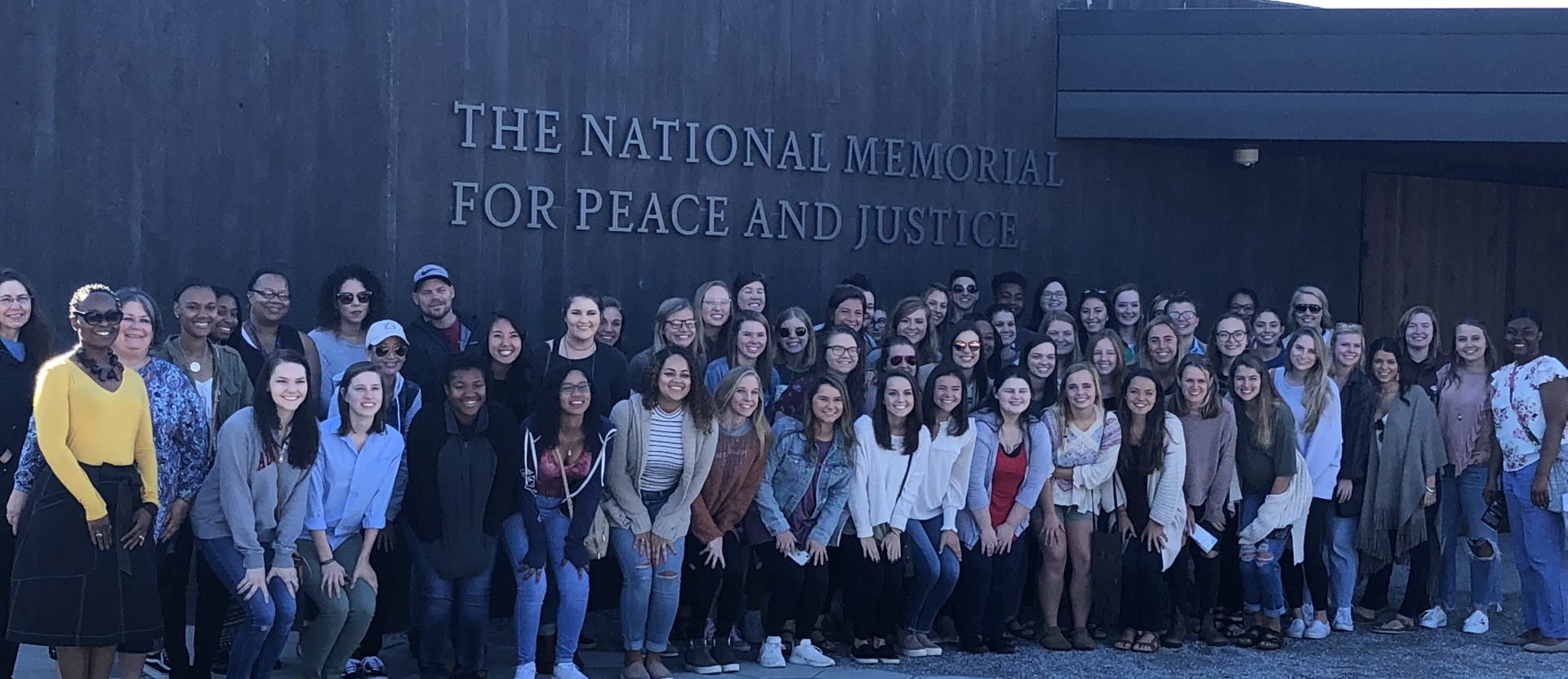 Social work class students standing in front of the National Museum for Peace and Justice