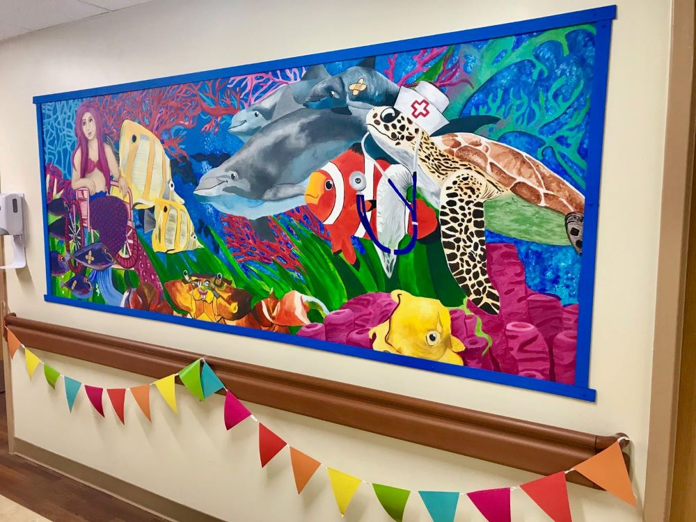 Mural featuring vibrant sea life wearing medical equipment