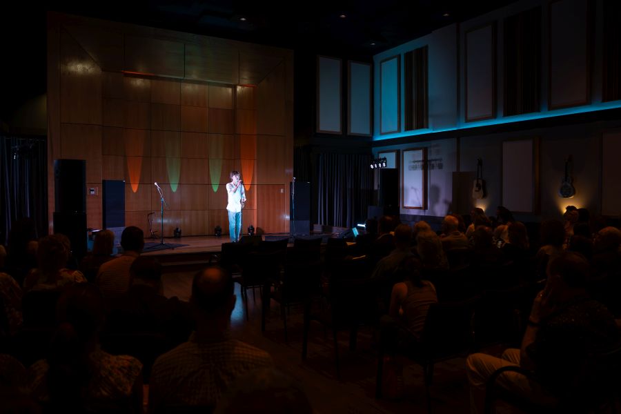 a man standing on a stage singing into a microphone