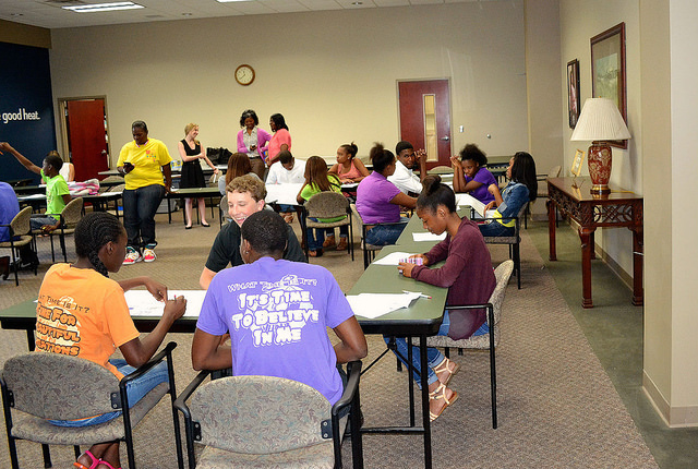 Youth sit at tables discussing community issues