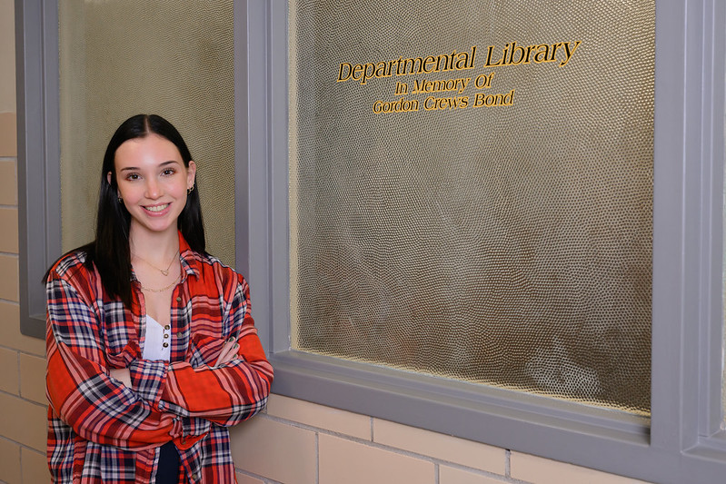 Emma Bond poses outside the Gordon Crews Bond Department of History library