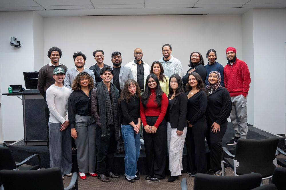 DeBose standing with a group of young professionals at an educational event