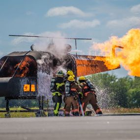 Firefighters hose down the burning shell of a helicopter
