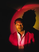 photo of man in a red jacket against a dark background