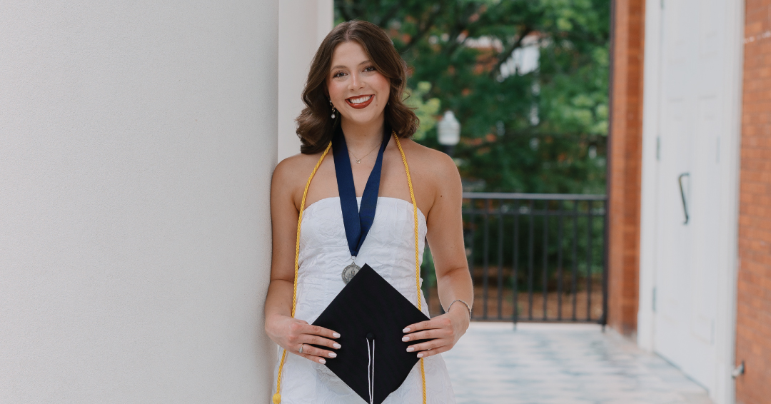 Grace Miles holding a graduation cap