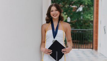 Grace Miles holding a graduation cap