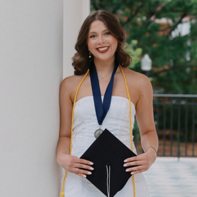 Grace Miles holding a graduation cap