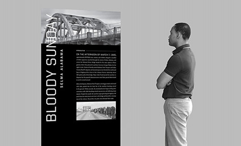 A man looks at a Selma Bloody Sunday display kiosk