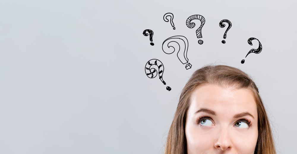 A woman thinking about something with question marks above her head