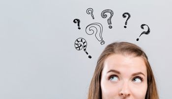 A woman thinking about something with question marks above her head