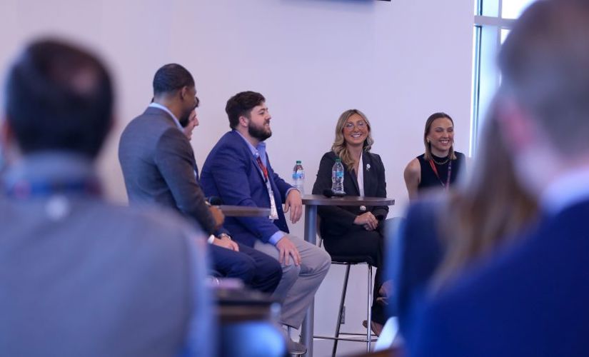 a group of people sitting on a stage talking to an audience