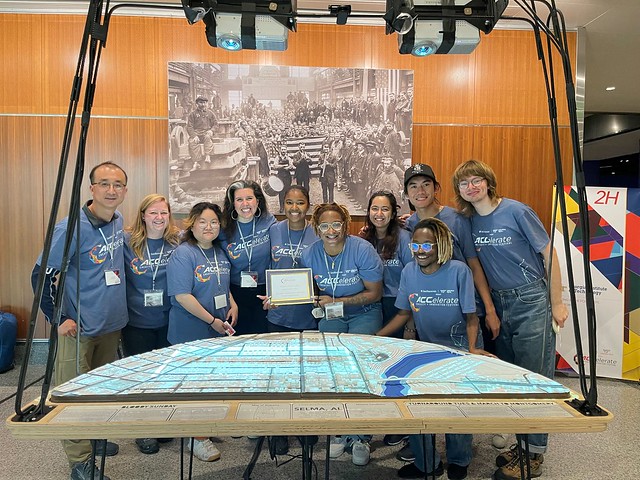 Researchers stand at Selma Exhibit holding People's Choice Award