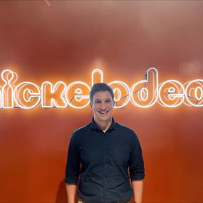 Caleb Eason stands in front of a neon NICKELODEON sign