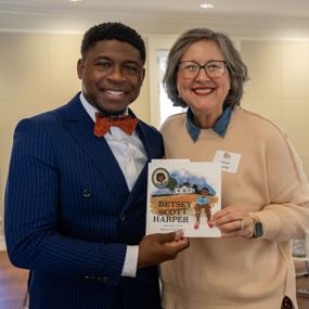 Author and illustrator holding copy of the Betsey Scott Harper children's book