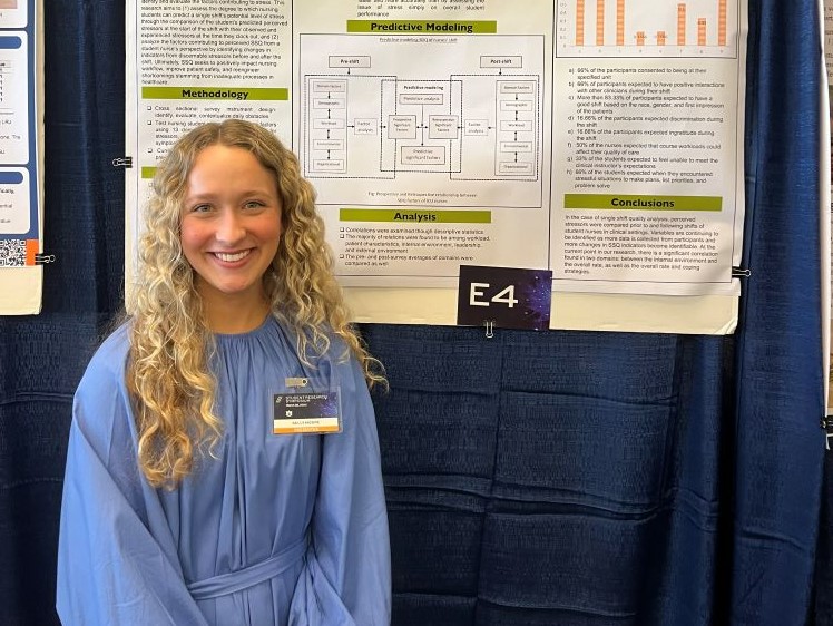 Kelly Moore stands beside her nursing students research poster presentation