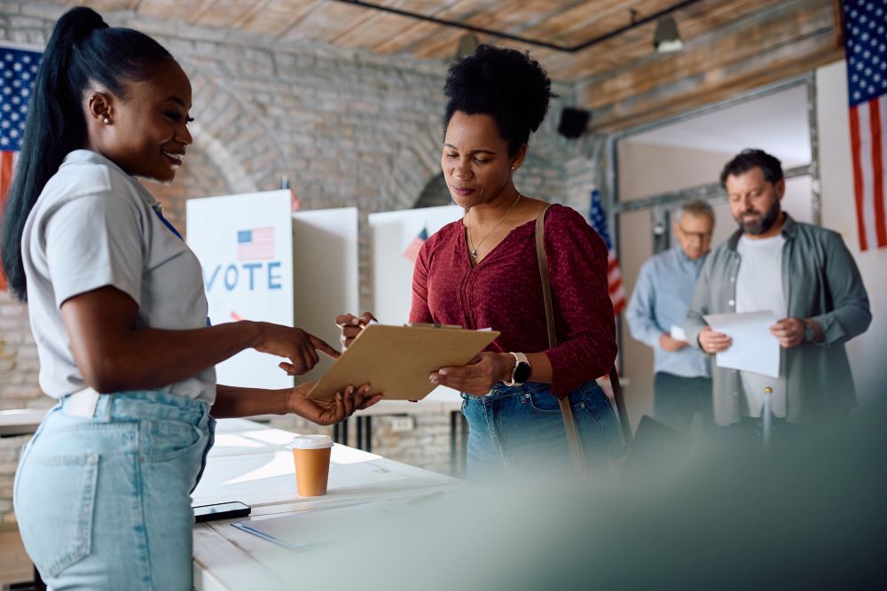 Poll worker helping woman at a voting place