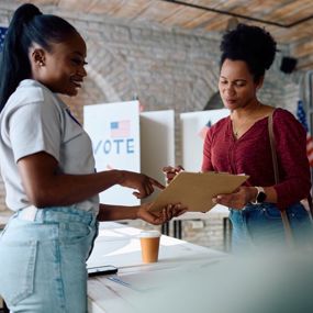 Poll worker helping woman at a voting place