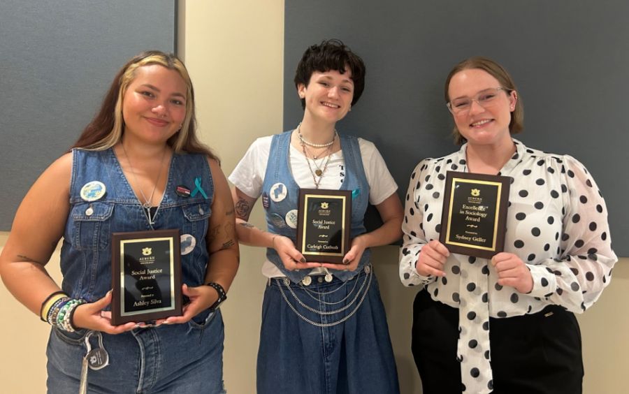 Students standing together each holding an award plaque