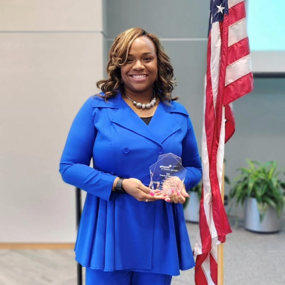 Tiffany McBride holding a Girl Scouts Woman of Distinction Award