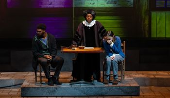 Judge presiding over two citizens, a man looking away and a woman crying, in the show Wellesley Girl