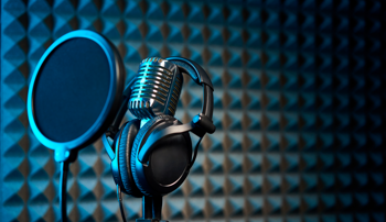 Microphone in a music studio with headphones looped around it