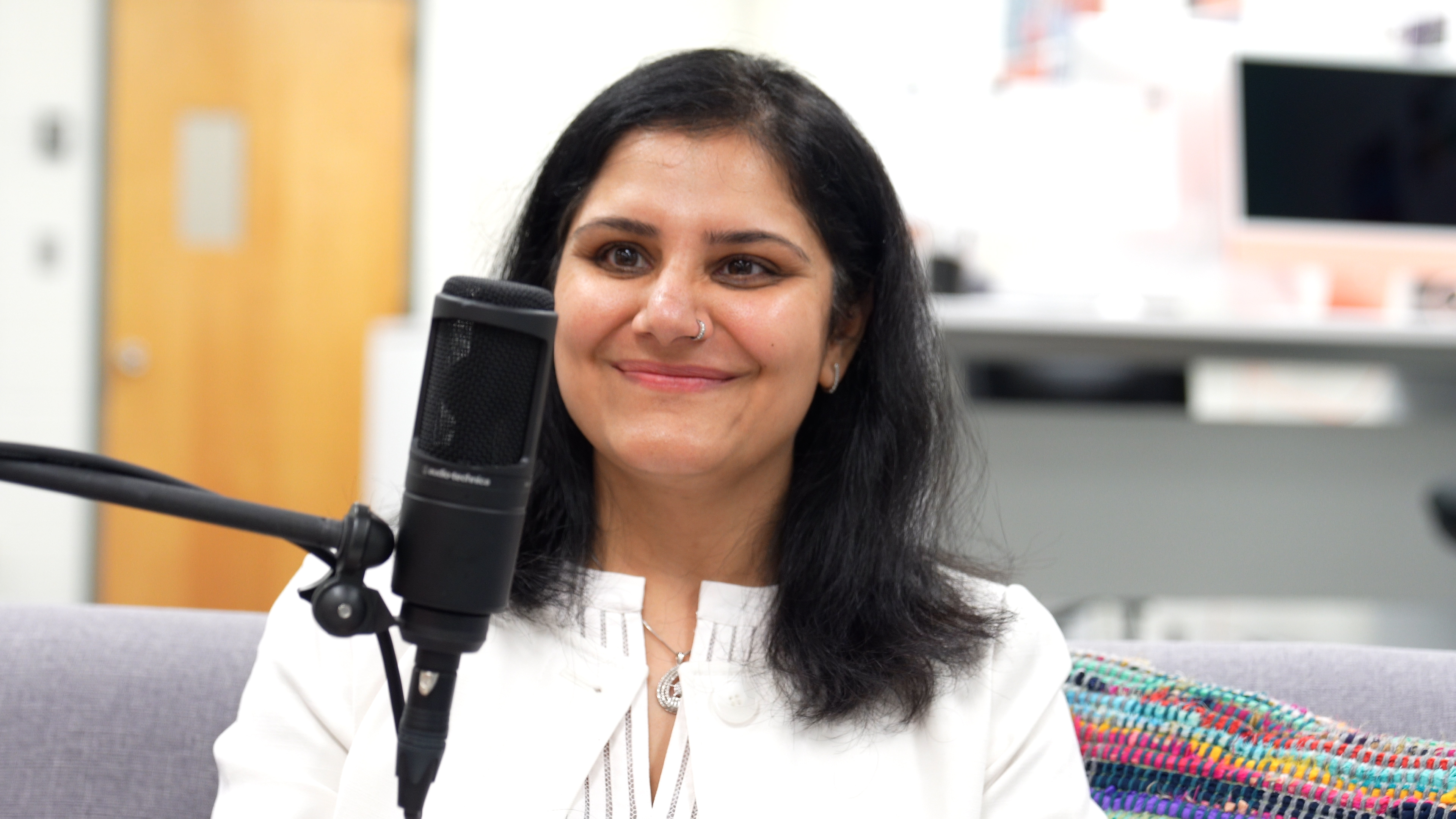 Dr. Gargi Sawhney sits behind a microphone while recording a podcast