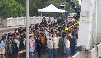 An yellow arrow points to Lowery McNeal in a crowd of extras filming Selma on the Edmund Pettus Bridge