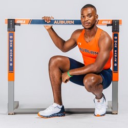 Oquendo Bernard poses with a hurdle in an Auburn track and field uniform