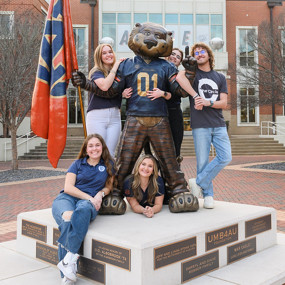 The Fab Five of Student Media pose for a group photo at the Aubie statue