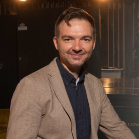 Andrew Lynch sits at a piano with title Composing Futures